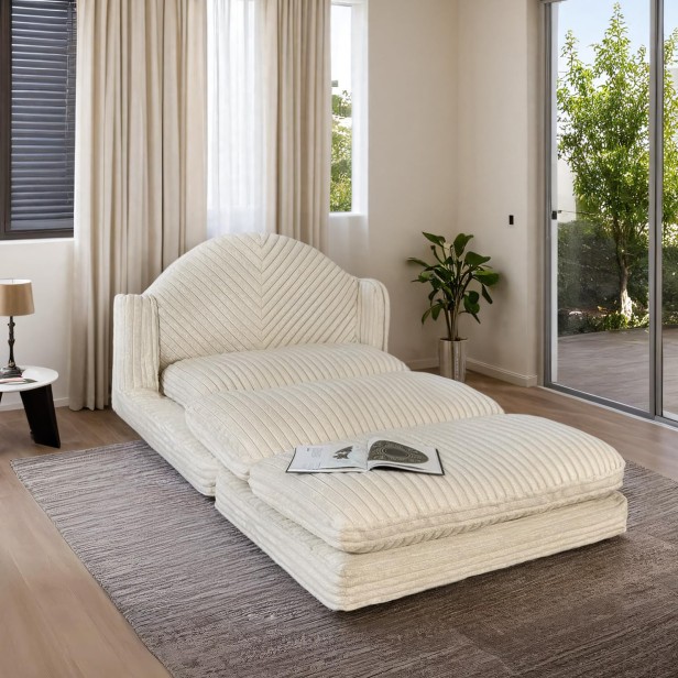 Rozłożona, modułowa sofa, fotel, tworząca wygodny szezlong lub leżankę w aranżacji w salonie.