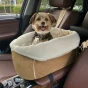 Mały, szczęśliwy pies siedzący w beżowym foteliku, transporter Samochodowy dla Psa na Podłokietnik z kremowym, puszystym wykończeniem