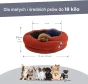 Okrągłe, przytulne legowisko dla psa w kolorze pomarańczowo-brązowym, z małym pieskiem w środku. Wymiary produktu.