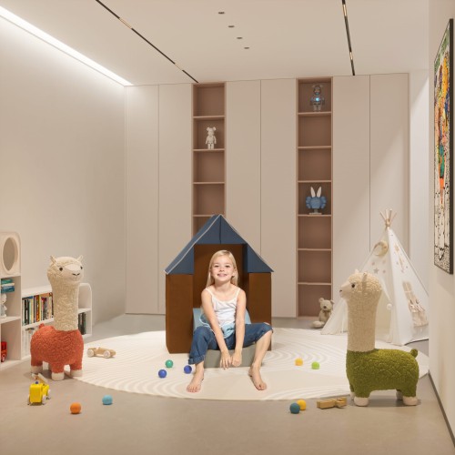 Dziewczynka siedząca na Sofie z Piankowych Bloków dla Dziecka.