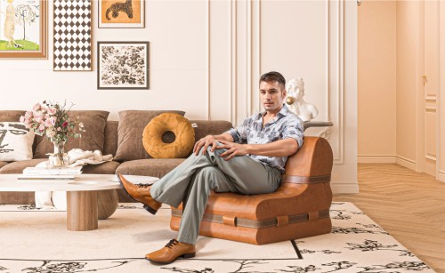 Mężczyzna siedzący w salonie na Kanapie z Ozdobnymi Pasami ze Skóry