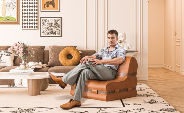 Mężczyzna siedzący w salonie na Kanapie z Ozdobnymi Pasami ze Skóry