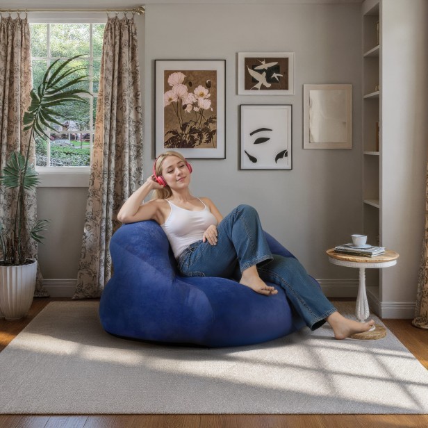 Pufa/Fotel Worek Niebieski, kobieta siedząca w fotelu w salonie.