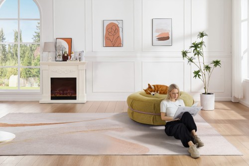 Kobieta opierająca się w salonie o Pufę Makaronik Zieloną na której leży pies.