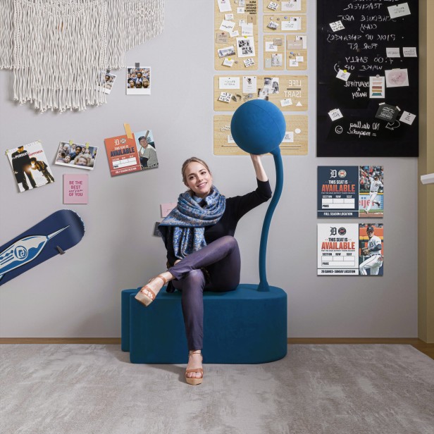 Kobieta siedząca na Nowoczesnej Niebieskiej Pufie.
