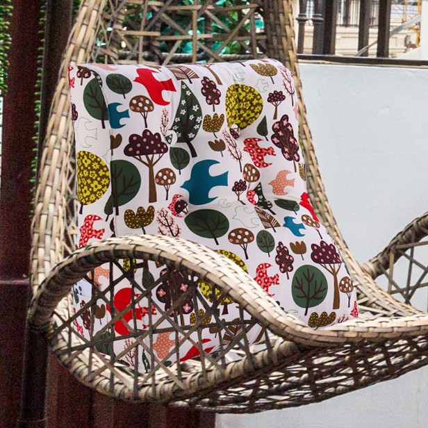 Wszechstronna Poduszka do Czytania Wzór Las, aranżacja w fotelu wiklinowym na tarasie.